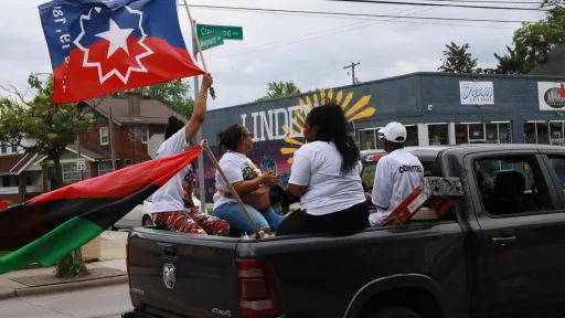People riding in the 2025 Juneteenth parade in the back of a pickup truck